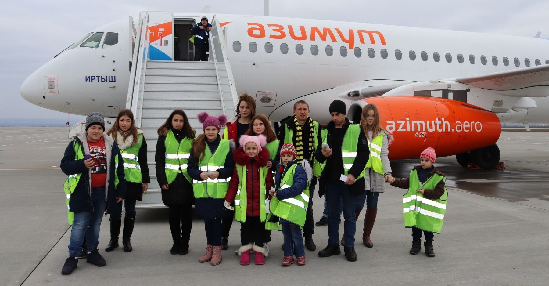 Воспитанники Большелогского центра помощи детям на фоне самолета